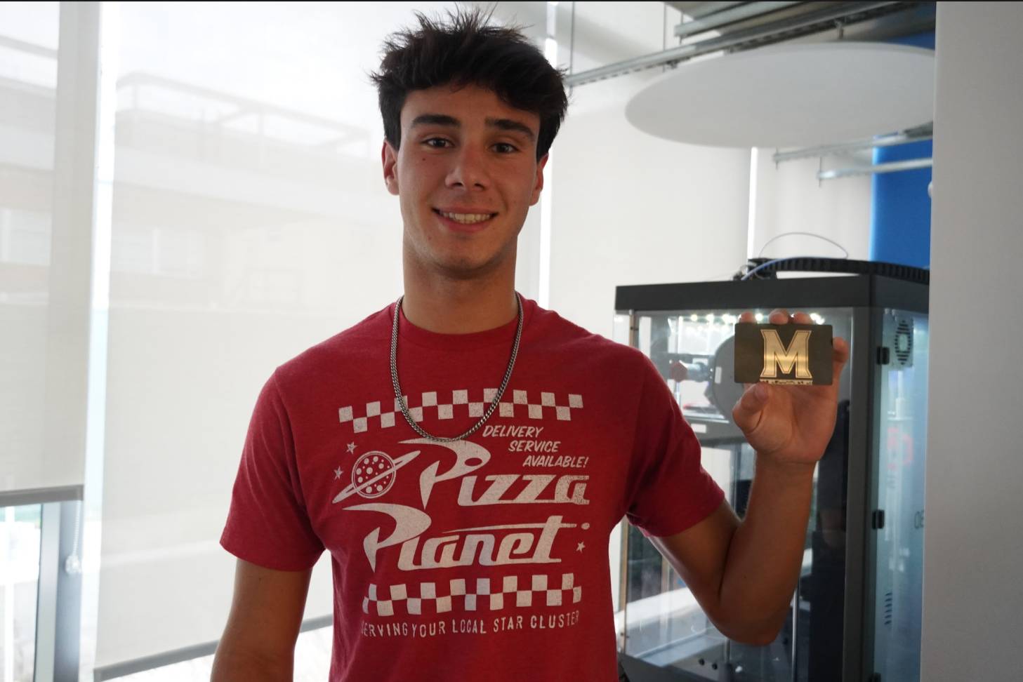 Student holding their custom metal card