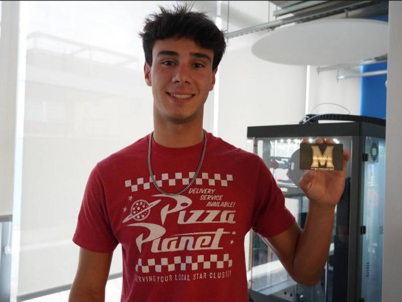 Student holding their custom metal card