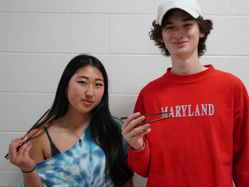 2 Students posing with their handmade chopsticks 